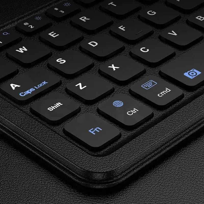 Close-up of black Bluetooth keyboard with blue and white keys on textured black surface